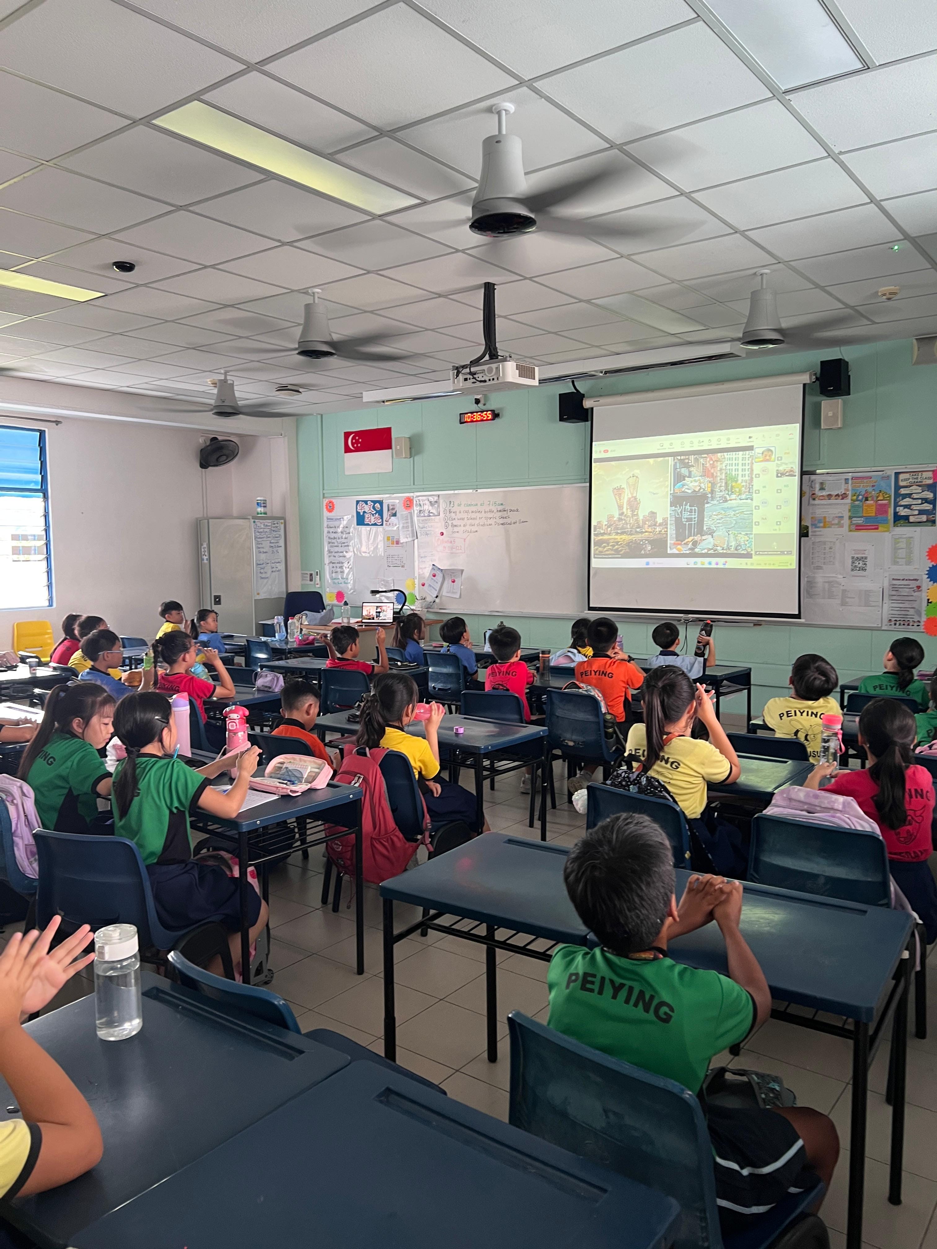 Students seated at desks watching a classroom presentation.